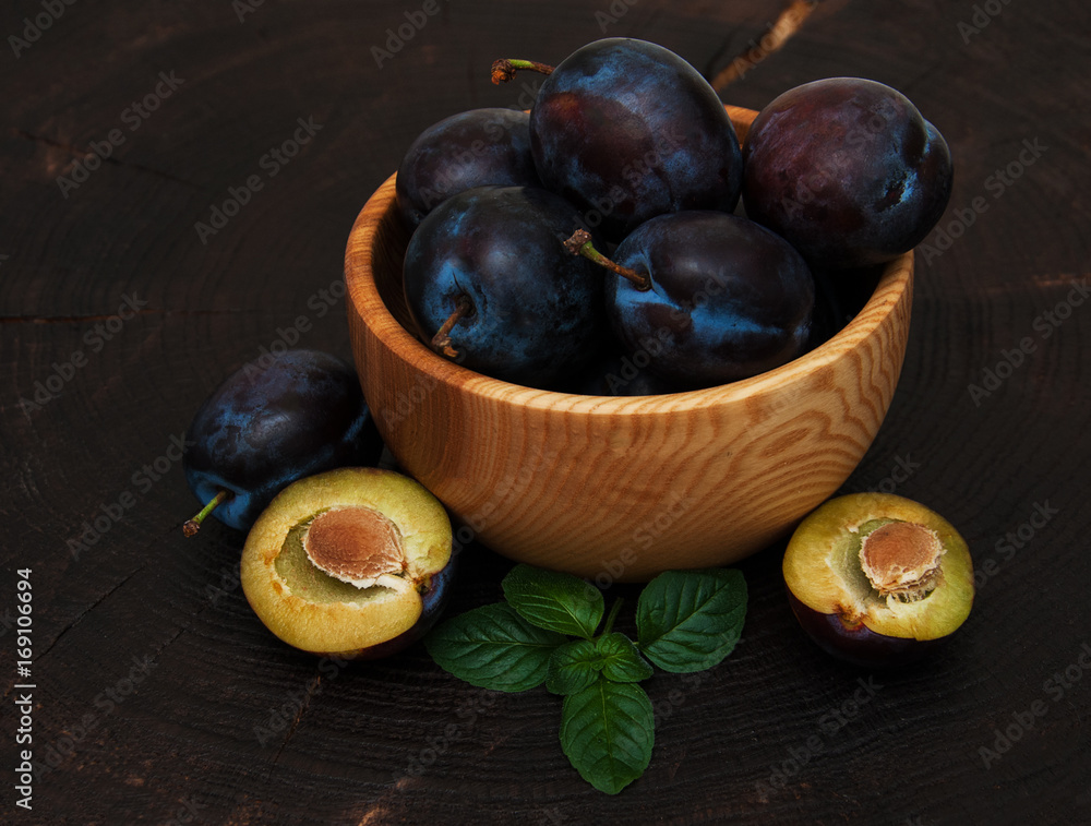 Bowl with plums with green leaves Bowl with plums with green leaves