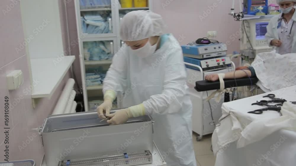 A team of nurses prepares surgical instruments for sterilization A team of nurses prepares surgical instruments for sterilization