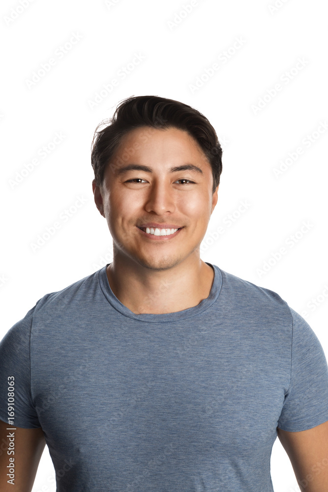 Handsome smiling man in his 20s, standing against a white background wearing a blue tshirt. Handsome smiling man in his 20s, standing against a white background wearing a blue tshirt.