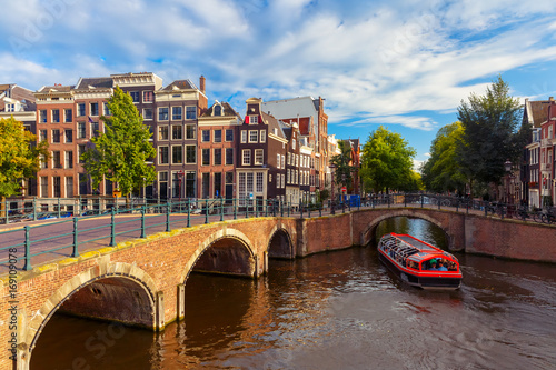 Canvas Print Amsterdam canal Reguliersgracht with typical dutch houses, bridge and houseboats during sunny morning, Holland, Netherlands