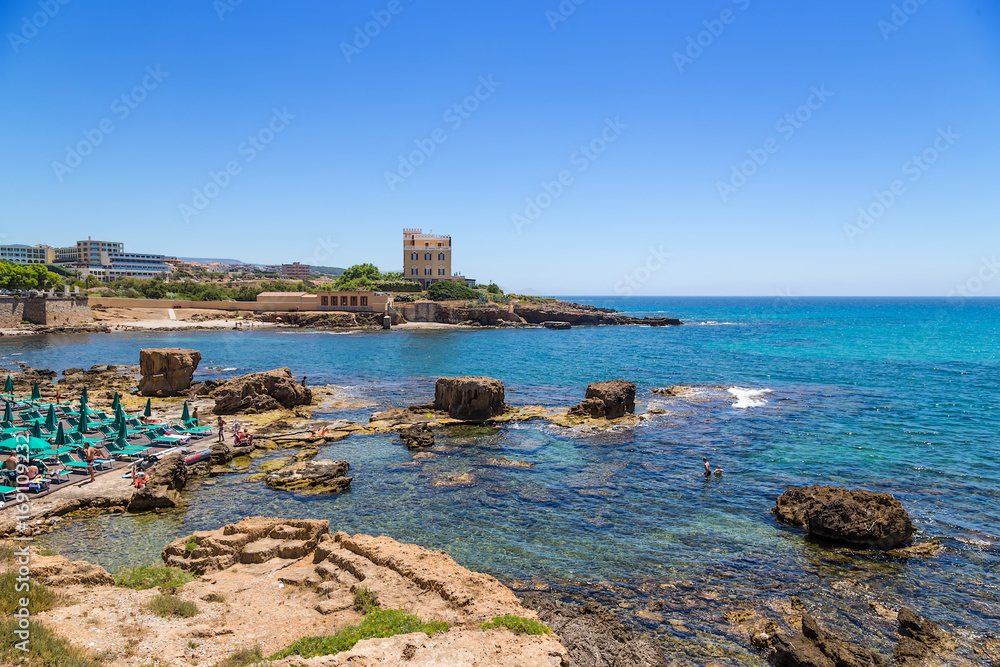 Alghero, Sardinia, Italy. The beach and clear sea water under the ancient fortress walls