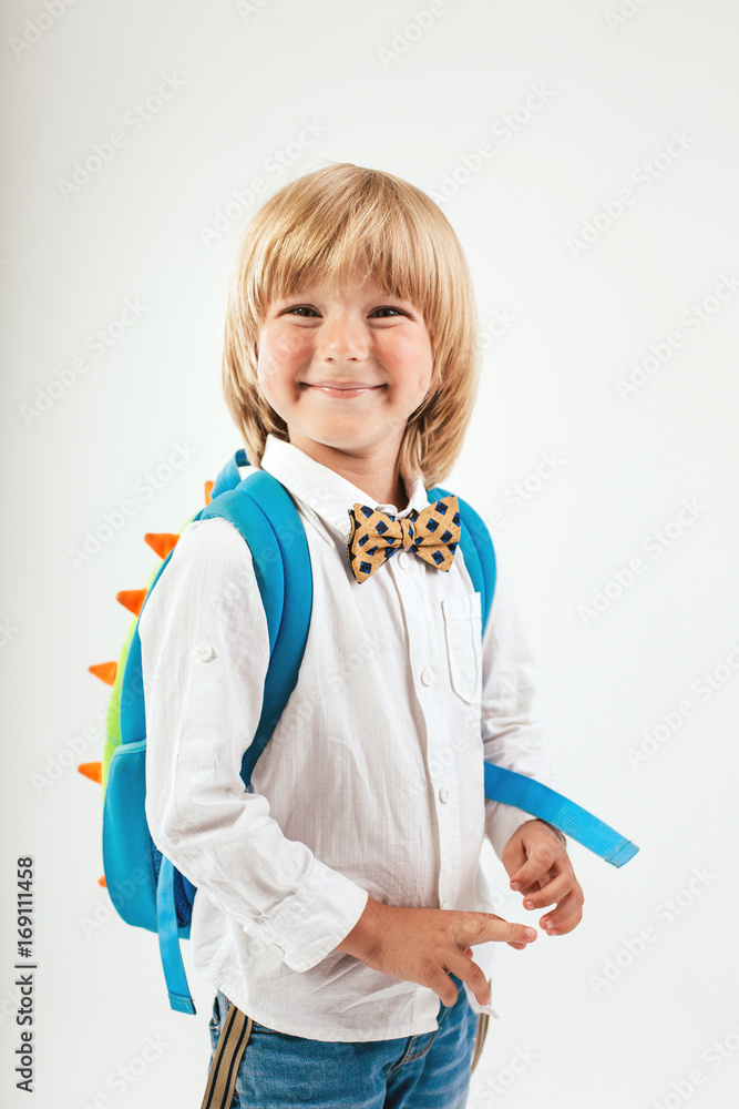 School, kid, rucksack. Little Boy dressed in bow tie. Cheerful smiling little kid with big backpack. Looking at camera. School concept. Back to School School, kid, rucksack. Little Boy dressed in bow tie. Cheerful smiling little kid with big backpack. Looking at camera. School concept. Back to School