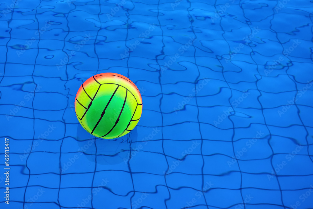 Beach ball floating in swimming pool abstract concept for summer vacations.