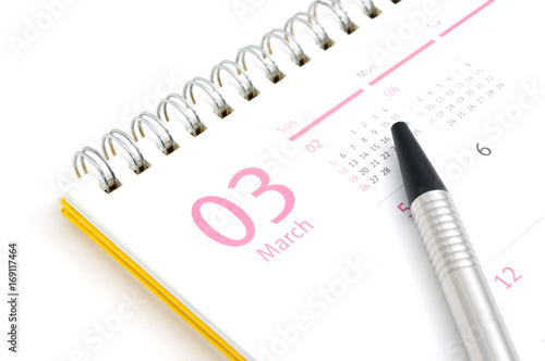 Desk calendar and pen on white background
