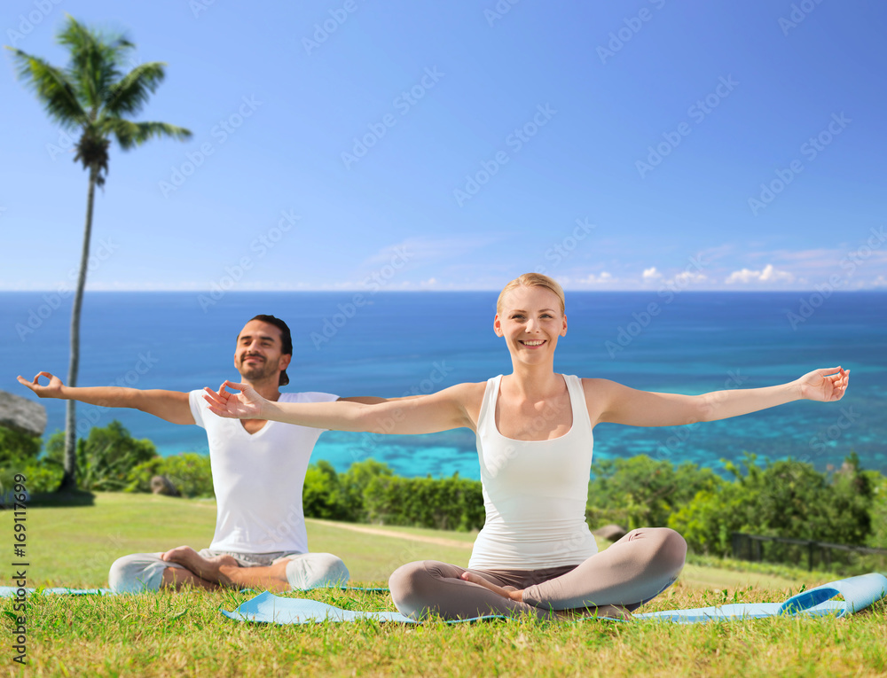 couple doing yoga in lotus pose outdoors