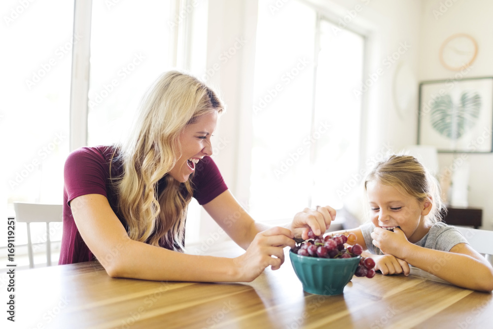 Mother and daughter (6-7) eating grapes Mother and daughter (6-7) eating grapes