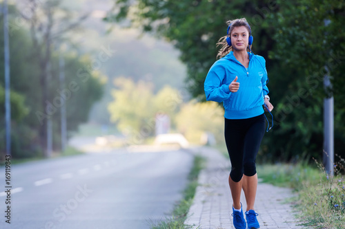 Cuadro en lienzo Urban woman jogger running by the road
