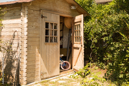 Small house cabin shed together with rich green vegetation and a lovely summer meadow