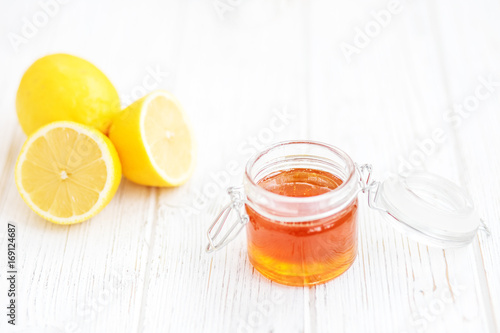 Honey in a glass jar and a lemon. Place for the inscription. The concept of healthy food, vegetarianism, autumn, colds,  treatment, cure, therapy, medication.