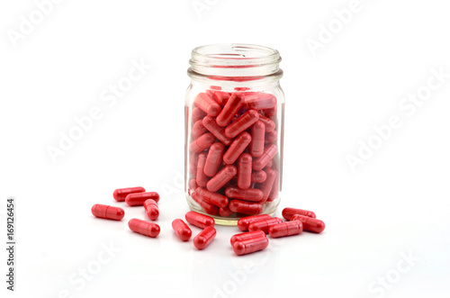 Natural organic herb vitamin capsule in bottle on white background.