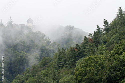 Karlovy Vary, Czech Republic - August 16, 2017:Forest with mist with the Diana Tower overhanging the city in the background
