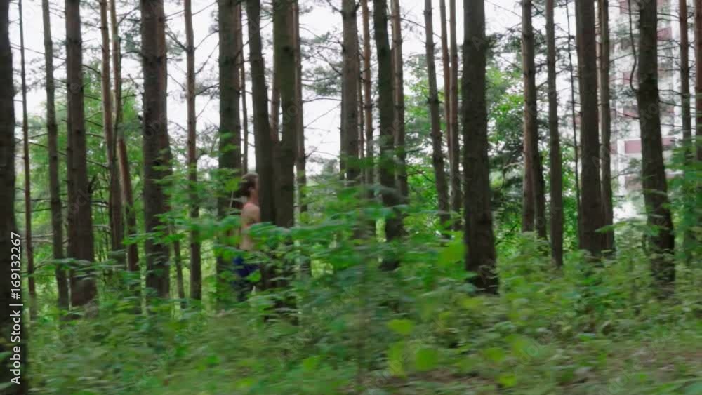 Woman athlete running in the forest, slow motion Woman athlete running in the forest, slow motion