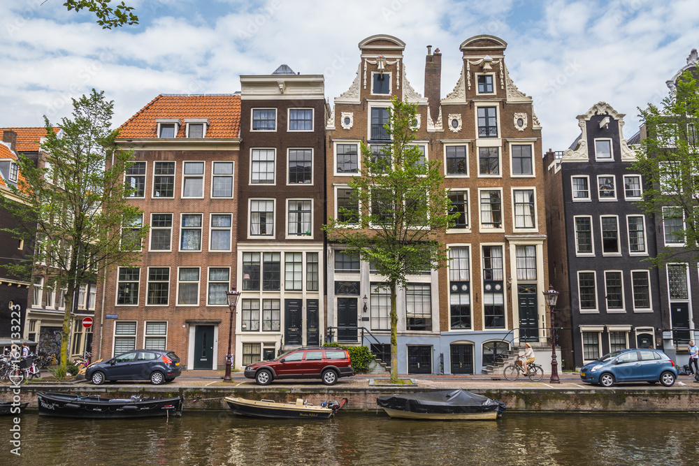 The amazing small houses at the canals in the city center of Amsterdam - AMSTERDAM - THE NETHERLANDS - JULY 20, 2017