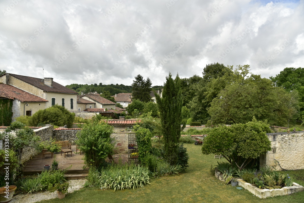 Jardins et maisons rustiques sous un ciel gris au village de Champagne ,au Périgord Vert