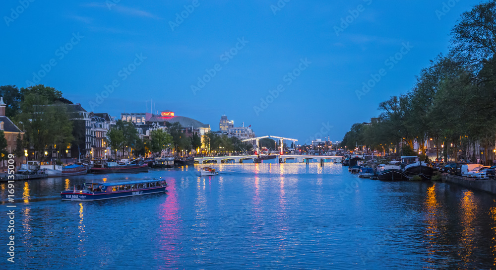 Evening view over famous Amstel River in the city of Amsterdam