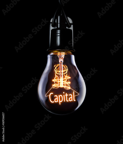 Hanging lightbulb with glowing Capital concept.