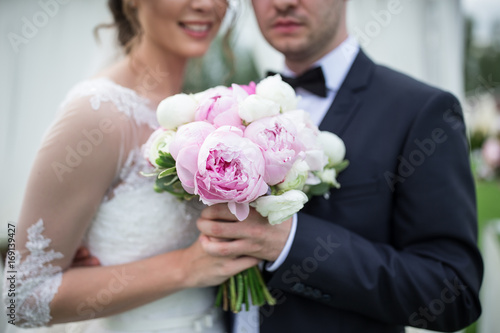 Bride and groom with a beautiful purple wedding bouquet