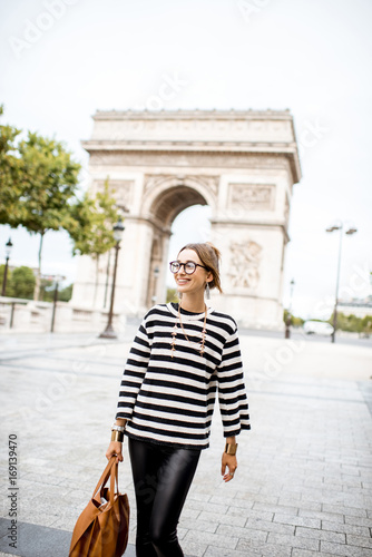Lifestyle portrait of a young stylish business woman walking outdoors near the famous triumphal arch in Paris © rh2010