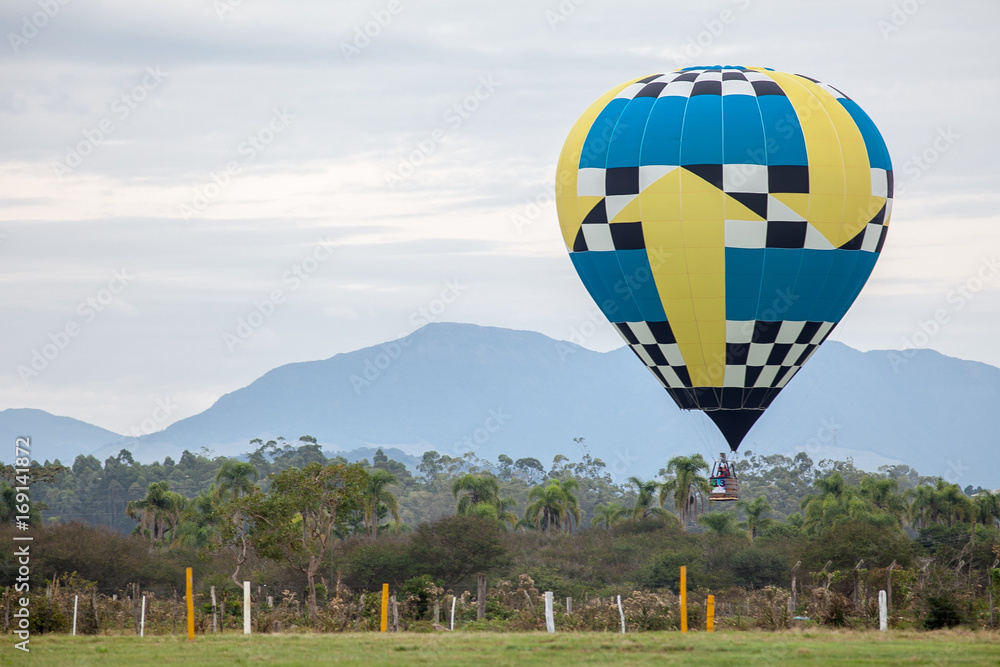 Obraz premium Balão voando com montanhas ao fundo