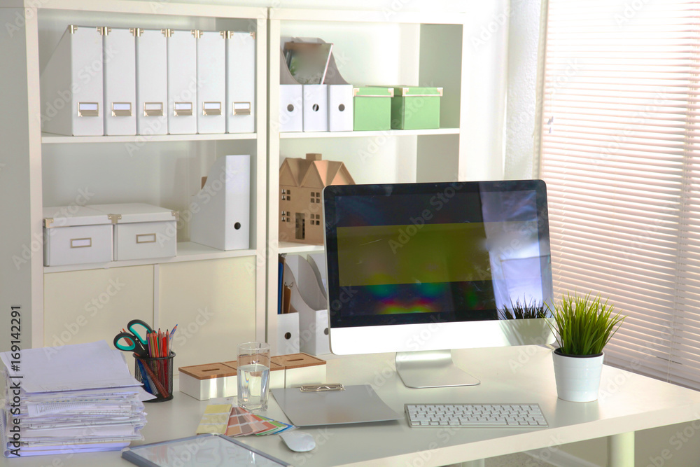 Office table with blank notepad and laptop