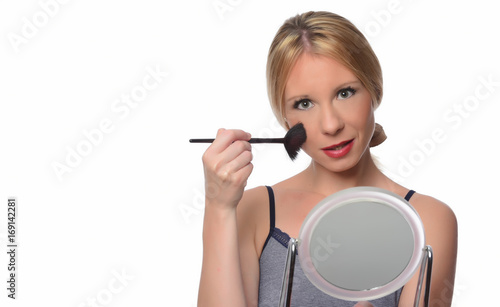  A young woman applying makeup on her face 