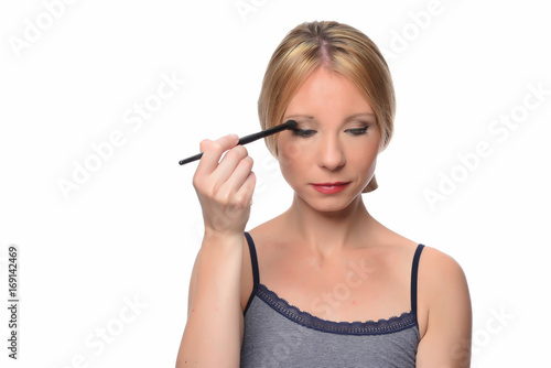  A young woman applying makeup on her face 