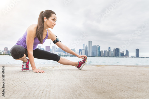 Woman doing stretching exercises with Chicago skyline on background
