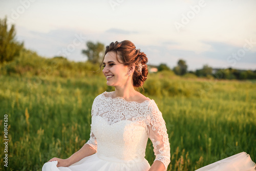 happy bride On the meadow near the forest on wedding day