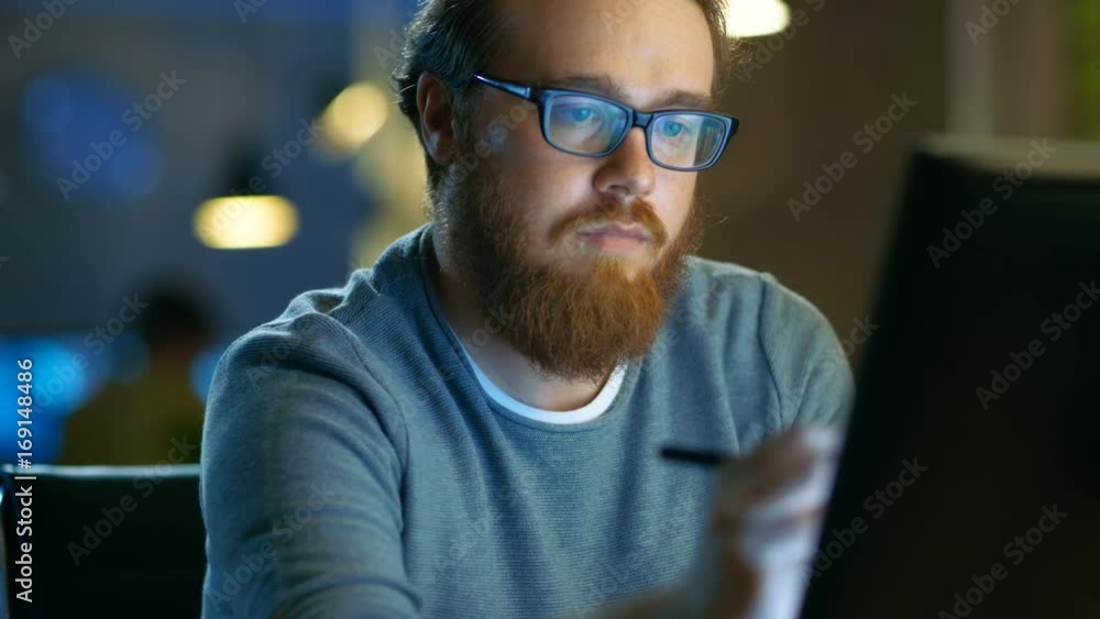 Talented Young Concept Artist Drawing on a Digital Pen Display Tablet While Sitting at His Working Place in Modern Loft Office. Late at Night. Shot on RED EPIC-W 8K Helium Cinema Camera.
