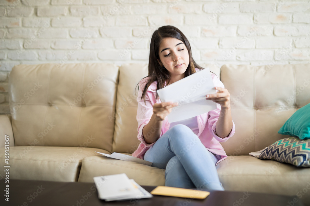 Latin woman reading letters in the living room Latin woman reading letters in the living room