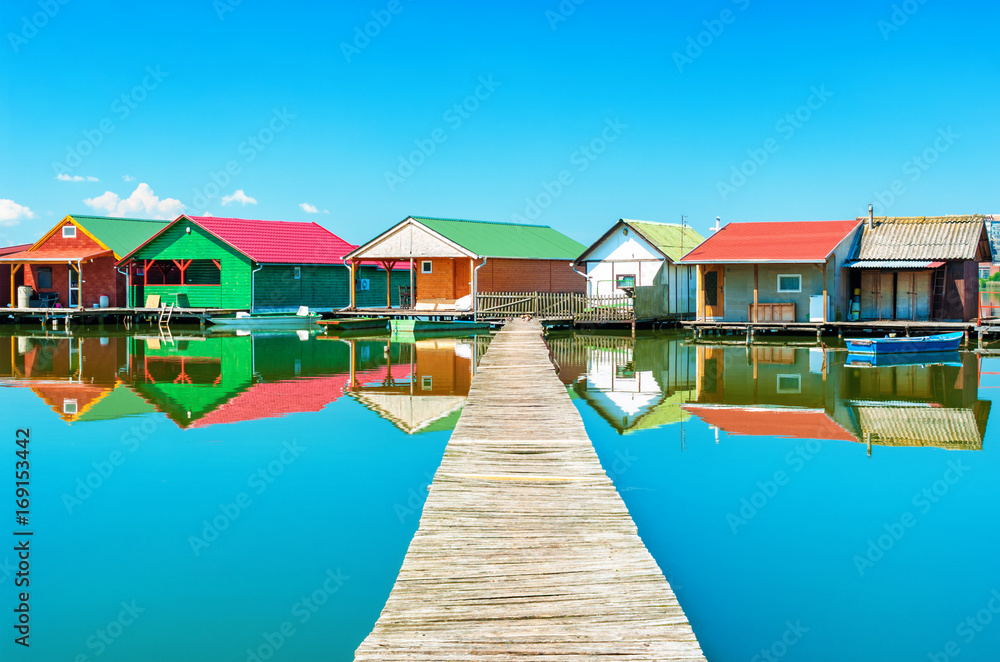 Old colorful fishing huts on a lake