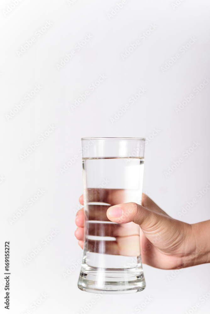 The hands of a beautiful woman holding a glass of water on a white background. The hands of a beautiful woman holding a glass of water on a white background.