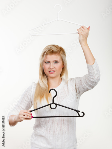 Blonde woman holding clothes hanger photo