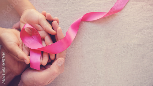 Adult and child hands holding pink ribbons, Breast cancer awareness, abdominal cancer awareness and October Pink panoramic background