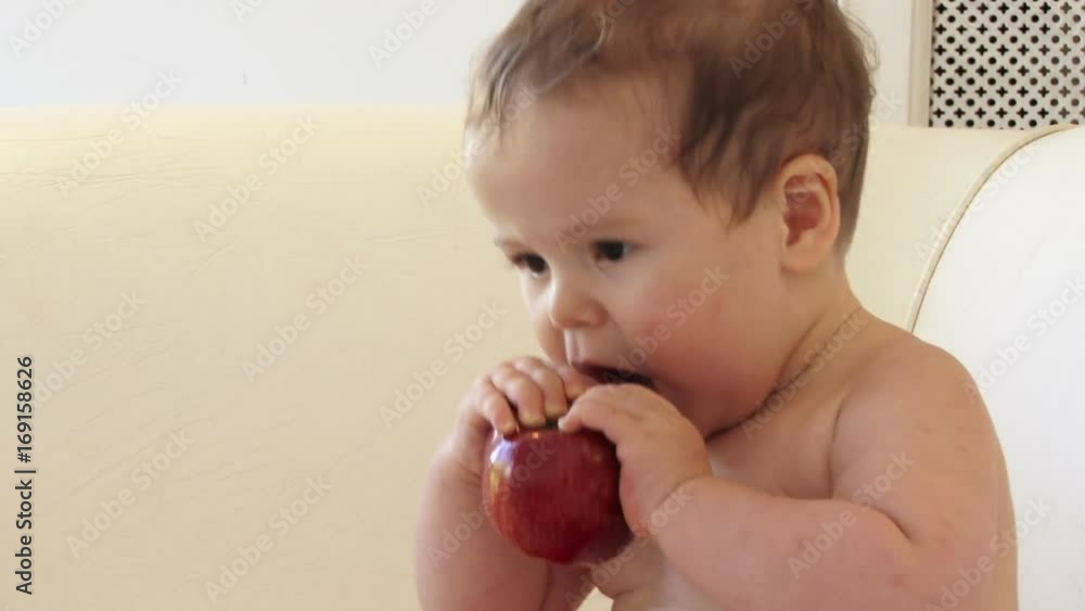 Child / baby boy eating and playing with a red apple apple. Child / baby boy eating and playing with a red apple apple.