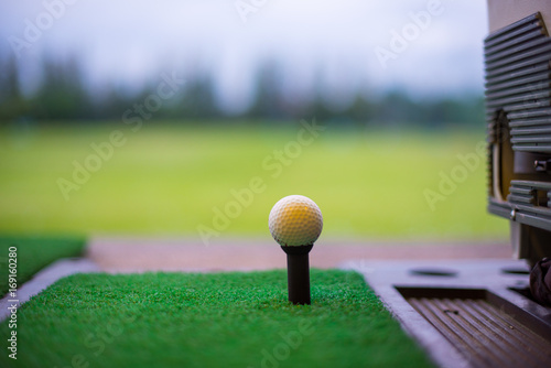 The golf ball on tee at driving range. Golf Driving Range with Golf Mat