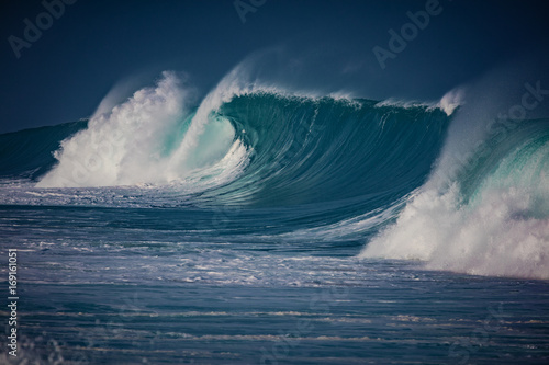 Big breaking ocean wave crashing on water surface of hawaiian aquatory photo