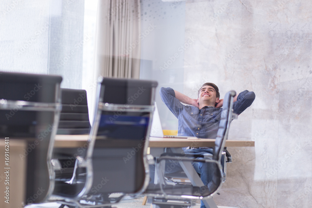 young businessman relaxing at the desk young businessman relaxing at the desk