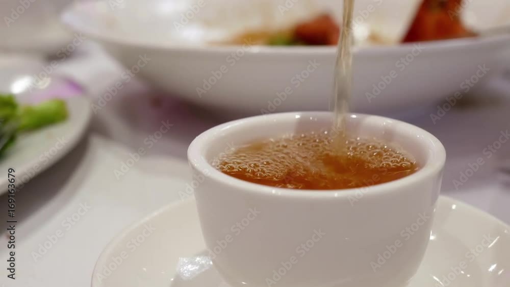 Pouring hot tea inside Chinese restaurant Pouring hot tea inside Chinese restaurant