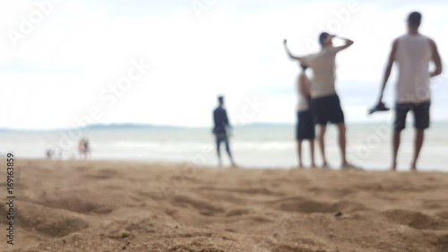 Blurry of sand beach and sea with travellers  background