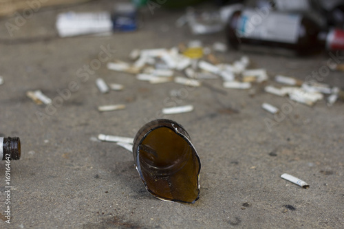 Photography broken bottles and cigarette butts on the ground