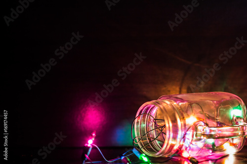 Garland lights in a water glass that bleary background.