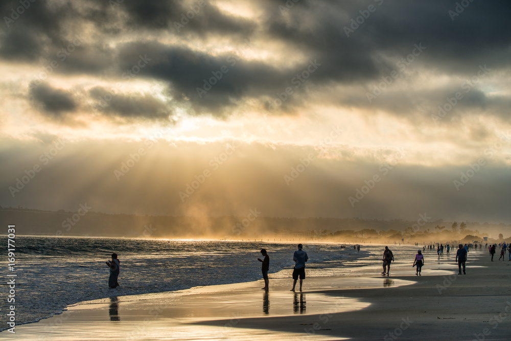 Backlit people on the beach at sunset, San Diego