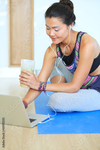 Sporty smiling woman using laptop in bright room. Woman. Lifestyle photo