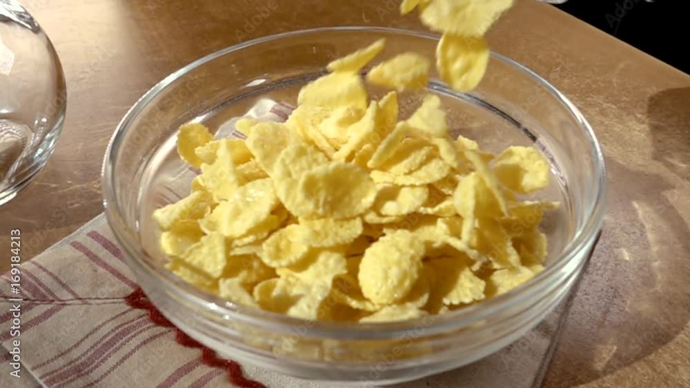 Crispy yellow corn flakes into the bowl for the morning a delicious Breakfast with milk. Slow motion with rotation tracking shot. Crispy yellow corn flakes into the bowl for the morning a delicious Breakfast with milk. Slow motion with rotation tracking shot.