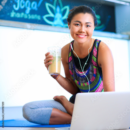 Sporty smiling woman using laptop in bright room photo