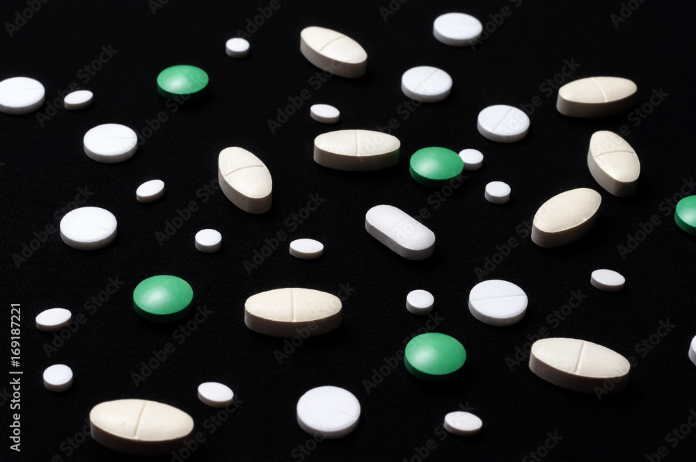 pills on black background with a medical syringe
