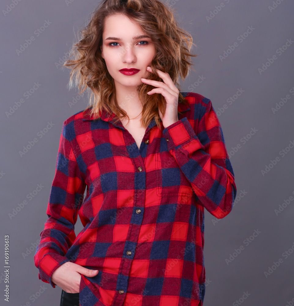 Young woman standing, isolated on gray background Young woman standing, isolated on gray background