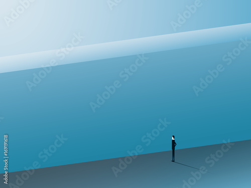 Businessman standing in front of huge wall as a symbol of business challenge and overcoming. Business challenge.