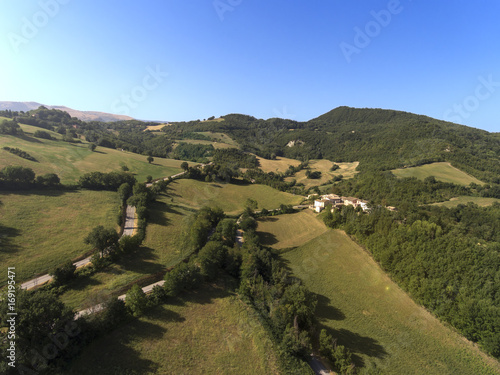 aerial shot of little village of Collevecchio, Macerata, Italy surrounded by nature of Monti Sibillini National Park photo